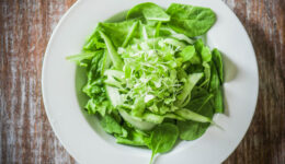 Salas with spinach,cucumber and microgreens on wooden background