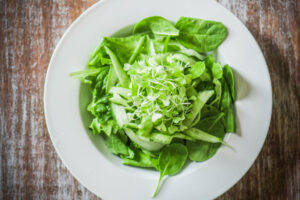 Salas with spinach,cucumber and microgreens on wooden background