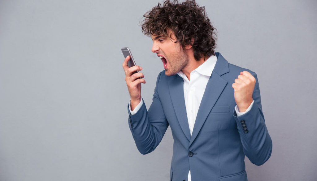 Angry businessman shouting on smartphone